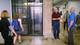 John Bryant, right, associate professor of construction science, talks with a visitor in front of an exposed elevator shaft at the dedication of Francis Hall; building systems were left exposed for use as a teaching aid. The building‘s interior renovation was recognized with an award by a builders’ group. 
